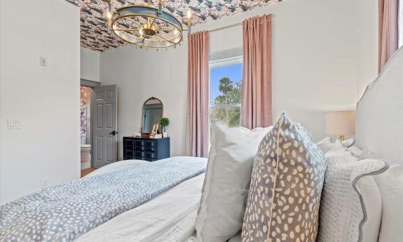 The bedroom in Apartment 2 at Three Stories Inn has a floral details and soft pink accents