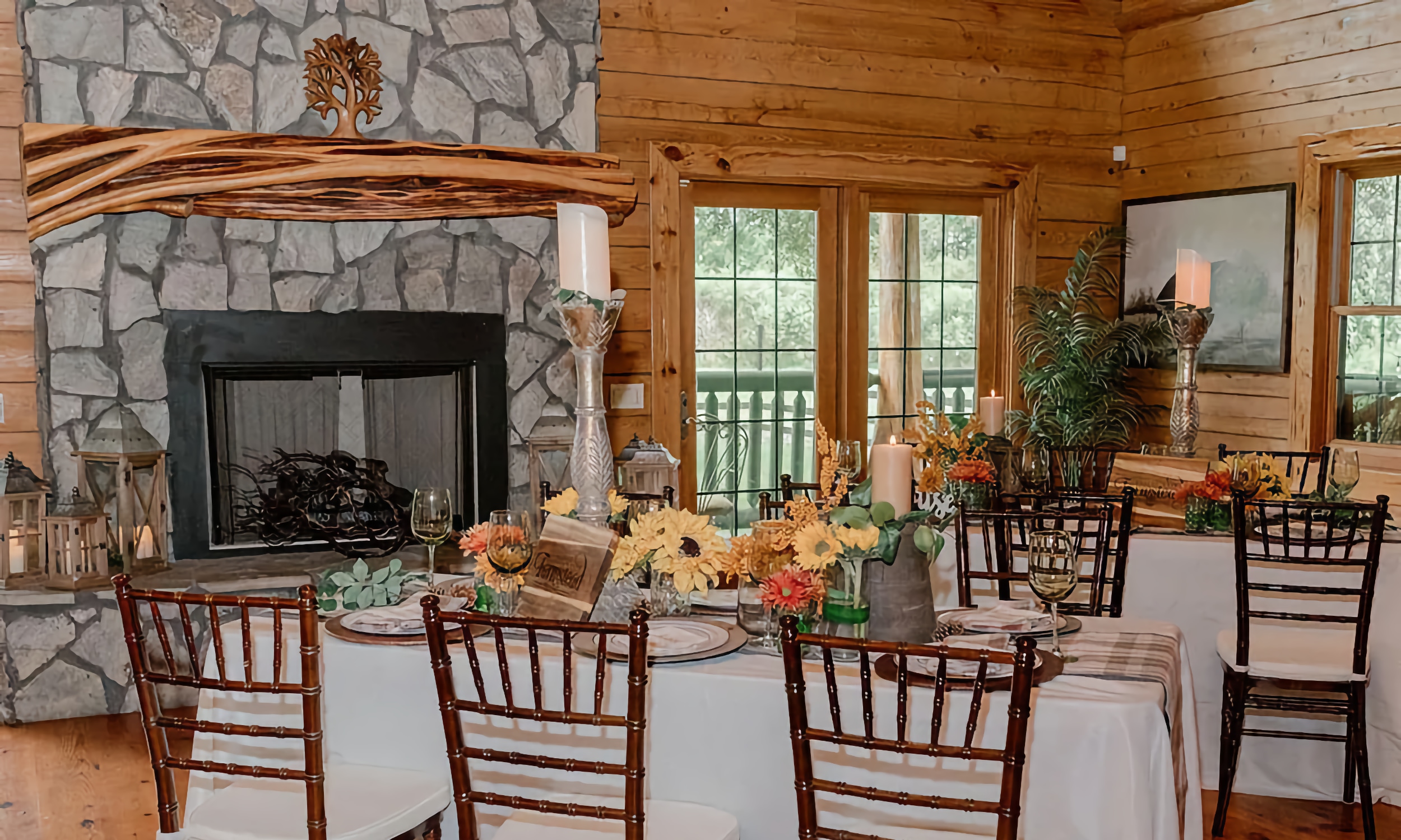 Tables arranged and decorated for an event near the stone fireplace at the Farmhouse at Ancient City Farmstead
