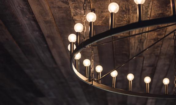 A detail of the large wheel chandelier against the barn board ceiling at Ancient City Farmstead