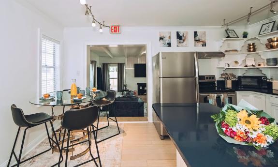 This kitchen and dining area shows a large countertop and the doorway to the den
