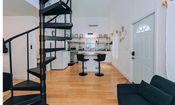 The tree house has an open first floor and a spiral staircase to the second floor balcony