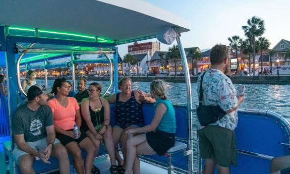 Guests on a Florida Water Tours boat chat while passing the bayfront