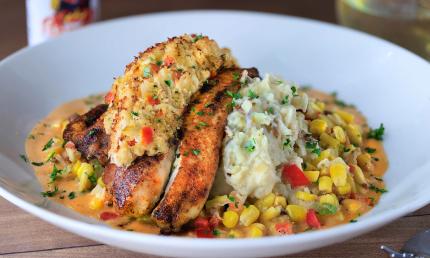 A serving of blackened redfish topped with crusted crab and served New Orleans style