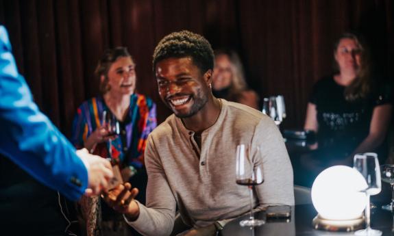 A gentleman in the audience smiles as he assists Master Magician Bill Abbott