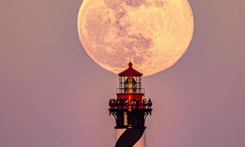 The top of the St. Augustine Lighthouse lit by a full moon