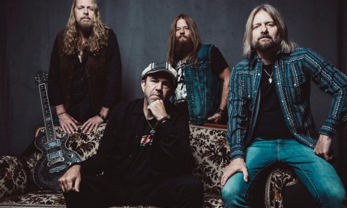 Bandmates from The Steepwater Band pose in front of a dark gray backdrop.