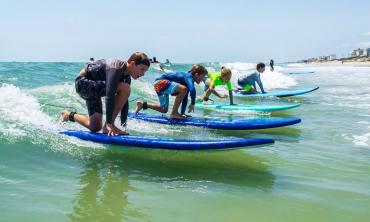 Children about to catch a wave on their surfboards