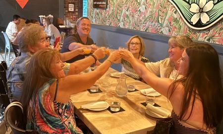 Six peoople raise their glasses while on a tasting tour