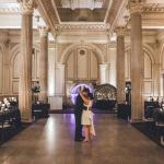 A bridal couple, alone in the venue, dancing