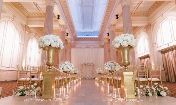 One arrangement for chairs at a wedding, with tall vases holding white flowers