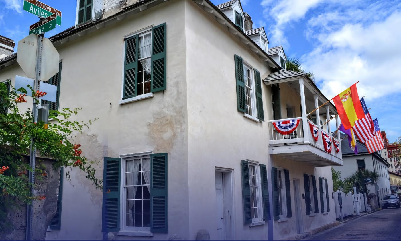 The street view of Ximenez-Fatio house festooned with bunting and flags on a sunny day