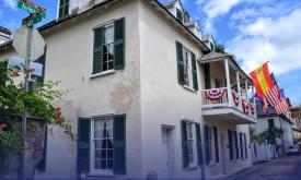 The street view of Ximenez-Fatio house festooned with bunting and flags on a sunny day