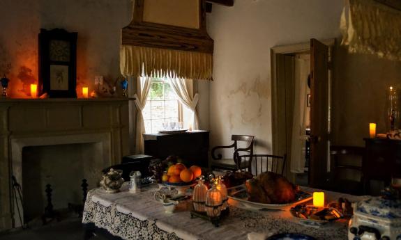 The darkened candlelit dining room decorated in the era of the 1800s during mourning