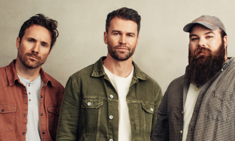 Bandmates from Ashes & Arrows pose in front of a beige backdrop.